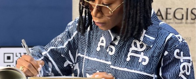 Singer-Songwriter Asa writes in the guest book at the Kigali Genocide Memorial, 2 Sept 2023